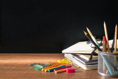 Ahşap masa arkasında okul malzemelerinin ön görüntüsü. Defterler, boş fotokopi alanı olan kağıtlar. Eğitim, okula dönüş konsepti.. 