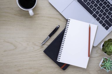 Ofiste, ahşap masası olan bir yerde. Not defteri ve kahveyle klavyenin üst görüntüsü. Modern yaratıcı tasarımcılar için yer var. Boş fotokopi alanı olan düz bir yer. İş ve finans kavramı.