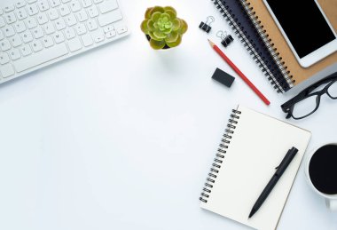 Ofiste beyaz bir masası olan bir iş yeri. Not defteri ve kalemle klavyenin üstünden en üstteki görünüm. Modern yaratıcı tasarımcılar için yer var. Fotokopi alanı olan düz bir yer. İş ve finans kavramı.