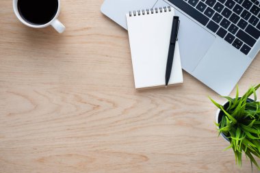 Ofiste, ahşap masası olan bir yerde. Dizüstü bilgisayarın üstünde kahve ve defter var. Modern yaratıcı tasarımcılar için yer var. Boş fotokopi alanı olan düz bir yer. İş ve finans kavramı.