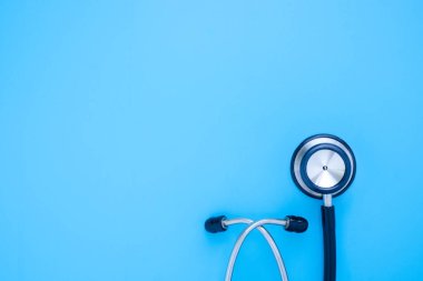 Siyah steteskop yakın plan doktor kontrol için mavi arka plan. Stetoskop ekipmanları, ses tanısı koymak için kullanılır. Fotokopi alanına sahip sağlık ve kardiyoloji kavramı.