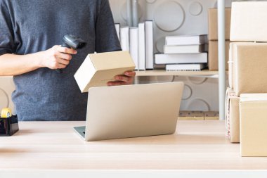 Asyalı genç akıllı işadamı veya Sme online girişimci sahibi, teslimat iş hisse senetleri veya parseller üzerinde ürün kontrol. Ev ofisinde çalışan genç küçük işletme sahibi.