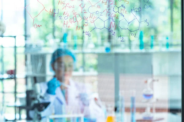 Blur Asian woman scientist, researcher, technician, or student conducted chemistry research and sitting after  glass board in laboratory — Stockfoto