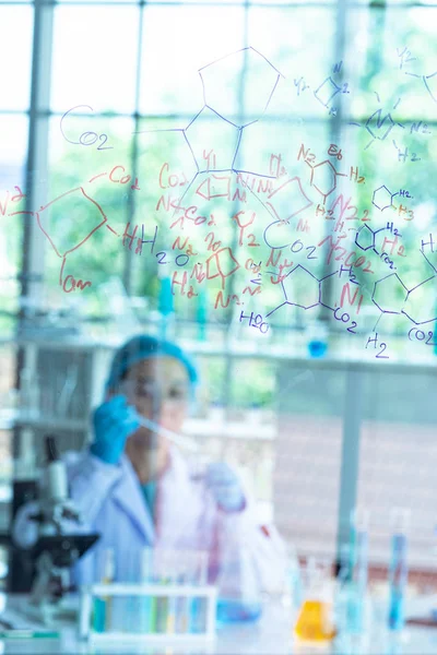 Блер Азіатська жінка вчений, дослідник, технік або студент провів хімічні дослідження і сидів за скляною дошкою в лабораторії. — стокове фото