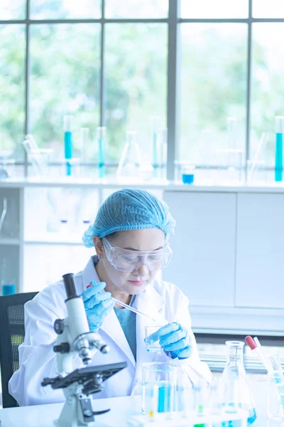 Asiatisk kvinna forskare, forskare, tekniker eller student forskat eller experimentera med Mikroskop som är vetenskaplig utrustning i medicinsk, kemi eller biologi laboratorium — Stockfoto