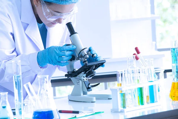 亚洲女科学家、女研究员、女技术员或女学生通过显微镜进行研究或实验，显微镜是医学、化学或生物实验室的科学设备 — 图库照片