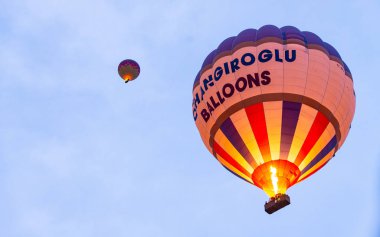 Goreme, Türkiye - 31 Aralık 2019: Goreme, Kapadokya üzerinde uçan renkli sıcak hava balonuna binen turistler