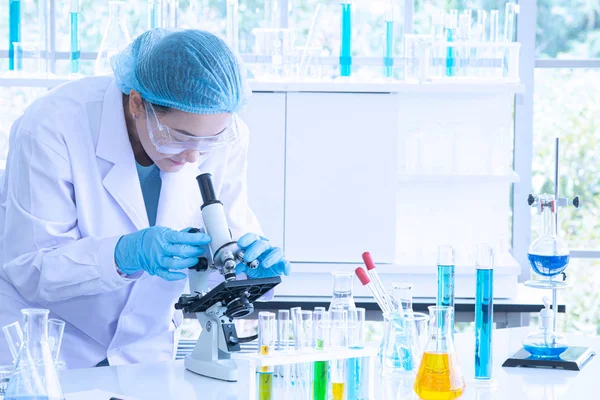 Asiatisk kvinna forskare, forskare, tekniker eller student forskat eller experimentera med Mikroskop som är vetenskaplig utrustning i medicinsk, kemi eller biologi laboratorium — Stockfoto