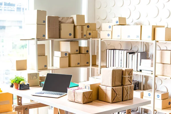 Sme çevrimiçi işleri için malzemeler, teslimat işi dizüstü bilgisayarı, barkod, kutular, hisse senetleri ve paketlerdeki ürünleri kontrol etmek. Ev ofisinde çalışan küçük işletmeler..