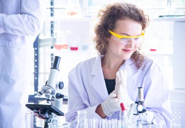 Bilim adamı biyolog ya da araştırmacı virüs ya da bakteri hastalığından korunmak için kişisel koruma ekipmanları koyuyor. Araştırmacı yeni virüs aşısını test ediyor ve yeniden ele geçiriyor.
