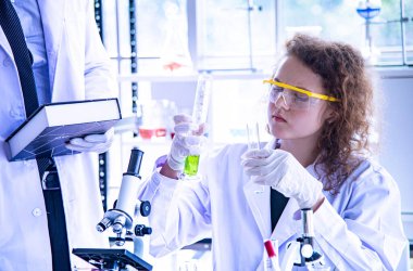 Bilim adamı biyolog ya da araştırmacı virüs ya da bakteri hastalığından korunmak için kişisel koruma ekipmanları koyuyor. Araştırmacı yeni virüs aşısını test ediyor ve yeniden ele geçiriyor.