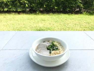 Domuz yumurtası ve sebzeli erişteyi kendin pişirmek kolaydır. Kriz durumundaki insanlar için kolay yiyecek ya da ekonomik durgunluk. Kahvaltı yapıyor ve bahçeye bakıyor..