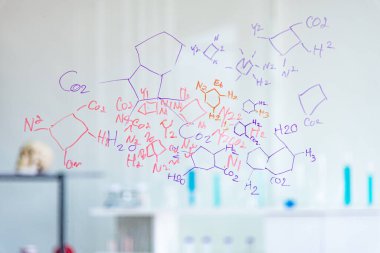 Bilim adamları, kimyagerler, laboratuvarda beyaz tahtaya yazılan kimyasal formülü keşfediyorlar. Araştırmacı, COVID19 enfeksiyonlu hastalar için aşı ya da ilaç keşfetti..