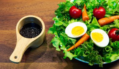 Beyaz tabak ve ahşap tabakta taze sebze salatası. Yeşil sebzeli havuç ve yumurta karışımı balzamik salata sağlıklı bir yemektir.