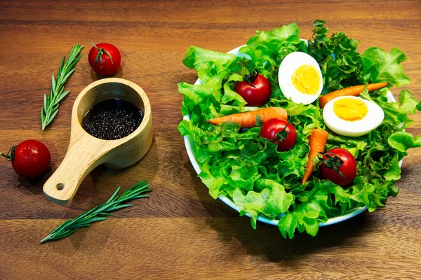 Beyaz tabak ve ahşap tabakta taze sebze salatası. Yeşil sebzeli havuç ve yumurta karışımı balzamik salata sağlıklı bir yemektir.