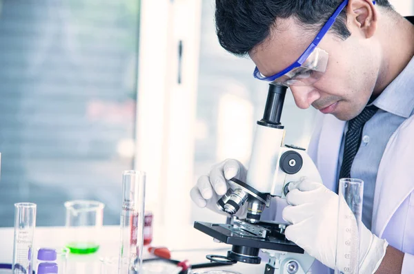 Bilim adamı biyolog ya da araştırmacı virüs ya da bakteri hastalığından korunmak için kişisel koruma ekipmanları koyuyor. Araştırmacı yeni virüs aşısını test ediyor ve yeniden ele geçiriyor.