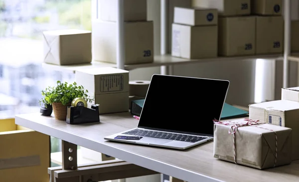 Sme çevrimiçi işleri için malzemeler, teslimat işi dizüstü bilgisayarı, barkod, kutular, hisse senetleri ve paketlerdeki ürünleri kontrol etmek. Ev ofisinde çalışan küçük işletmeler..