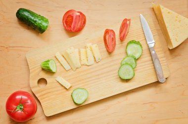 Doğranmış salatalık, peynir ve domates bir mutfak gemide vardır. 