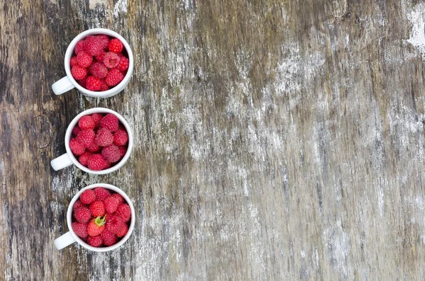 Three white cups with raspberries — Stock Photo, Image