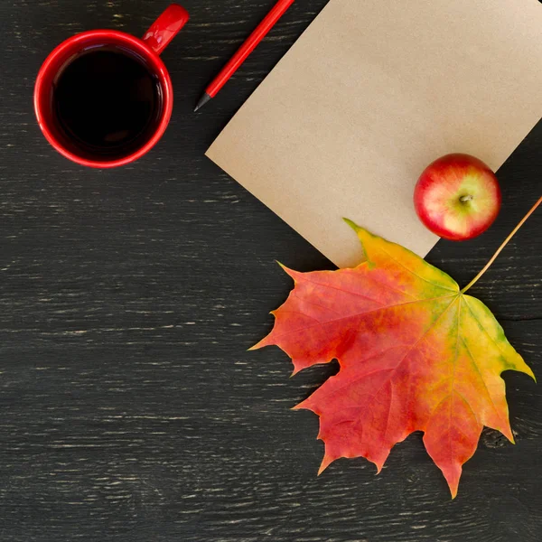 Sonbahar akçaağaç yaprağı, elma, fincan çay, kağıt, metin ve kalem