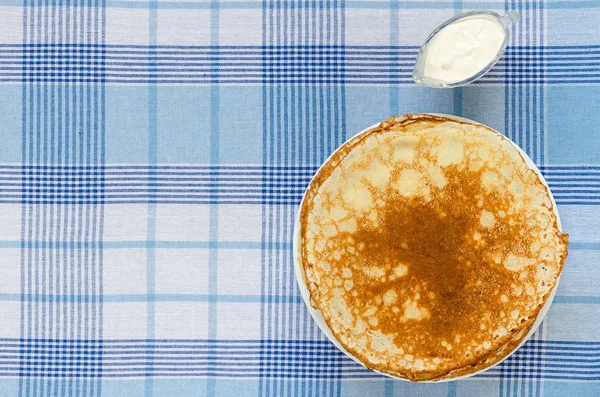 Pancake Rusia dengan krim asam di taplak meja — Stok Foto