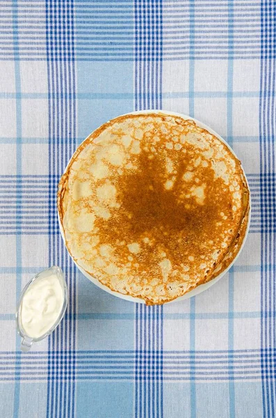 Pancake Rusia dengan krim asam di taplak meja — Stok Foto