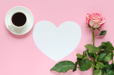 Pembe çiçek taze gül çiçek fincan kahve ve kağıt kalp pembe arka plan üzerinde metin için