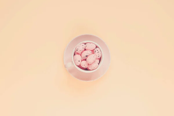 Pink easter eggs in coffee cup. Easter holiday background