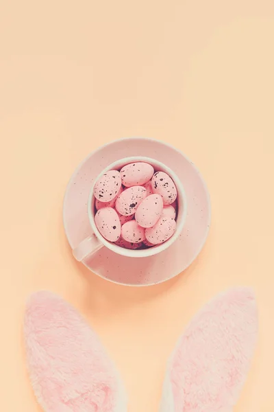 Easter holiday background with bunny ears and easter eggs in coffee cup