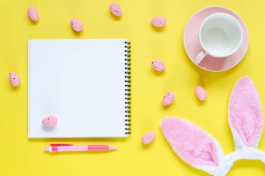 Paskalya tatili arka plan ile defter ve kalem, fincan kahve, tavşan kulakları ve Paskalya yumurtaları için