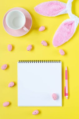 Paskalya tatili arka plan ile defter ve kalem, fincan kahve, tavşan kulakları ve Paskalya yumurtaları için