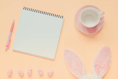 Paskalya tatili arka plan ile defter ve kalem, fincan kahve, tavşan kulakları ve Paskalya yumurtaları için