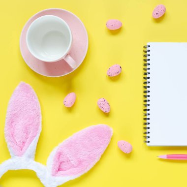 Paskalya tatili arka plan ile defter ve kalem, fincan kahve, tavşan kulakları ve Paskalya yumurtaları için