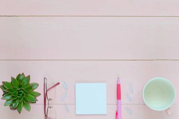 Biurko kobieta z różowe pióra, papieru, filiżanka kawy, okulary i soczyste — Zdjęcie stockowe