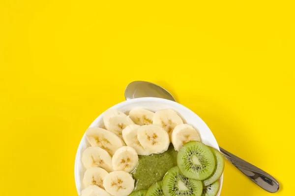 Groene smoothie in een witte kom op gele achtergrond — Stockfoto
