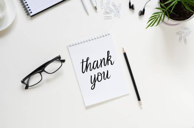 Çalışma alanı kalem, kağıt, kahve fincanı, bardaklar, yeşil bitkiler ve ofis malzemeleri. Üst kattaki daire tepemizde duruyordu. Çalışanların takdir günü konsepti