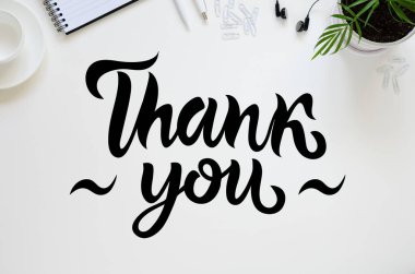 Çalışma alanı kalem, kağıt, kahve fincanı, bardak ve ofis malzemeleri. Üst kattaki daire tepemizde duruyordu. Siyah harfler. Teşekkürler.