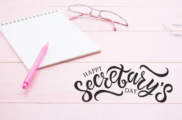 Not defteri, pembe kalem ve gözlüklü kadın masası. Uzayı kopyala. Seçici odaklanma. Sekreterler günün kutlu olsun.