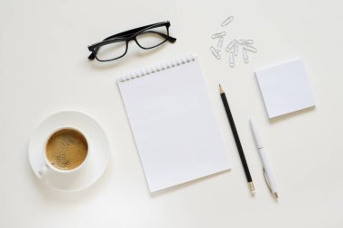 Çalışma alanı kalem, kağıt, kahve fincanı, bardak ve ofis malzemeleri. Üst kattaki daire tepemizde duruyordu. Boşluk arkaplanı kopyala