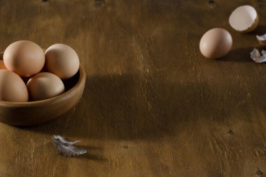 Tahta bir masada bej yumurtalı ahşap kase. Organik yiyecekler. Paskalya konsepti. Seçici odak