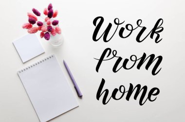 Dengeli çiçek buketi, çalışma alanı üzerine defter ve kalem. Evden Yazma Çalışması