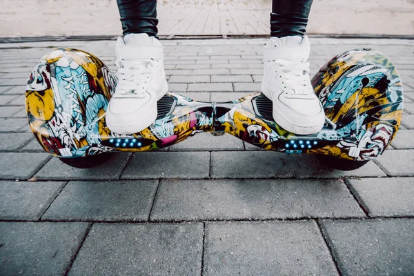 Chica en zapatillas blancas de pie en el scooter giratorio — Foto de Stock