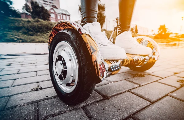 Girl in white sneakers standing on the gyro scooter Royalty Free Stock Images