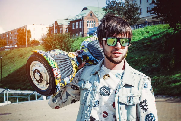 Trendy guy holding on his shoulder gyro scooter Stock Photo