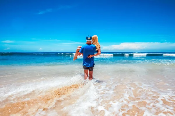 El tipo está llevando a su novia al océano. Imágenes De Stock Sin Royalties Gratis