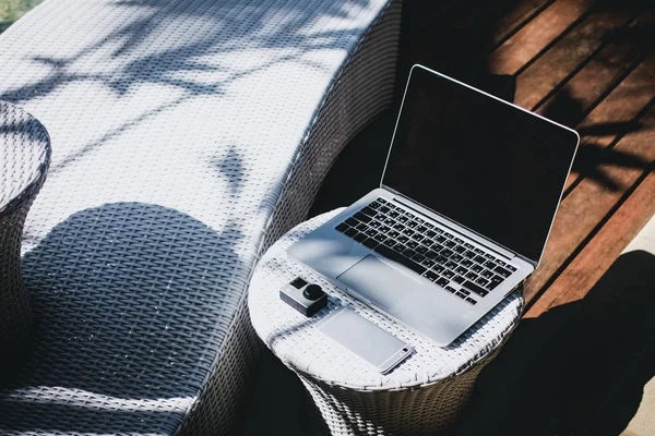 Laptop, smarphone, akční kameru na stůl, přístroj poblíž lehátku — Stock fotografie