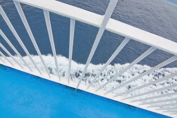 Closeup white railing foamy Mediterranean water — Stock Photo, Image