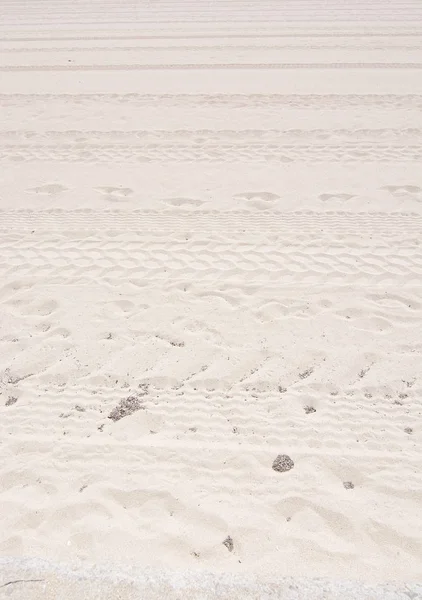 Rastreamentos e pegadas na praia de areia — Fotografia de Stock