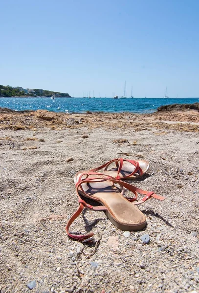 Sandálias na praia arenosa — Fotografia de Stock