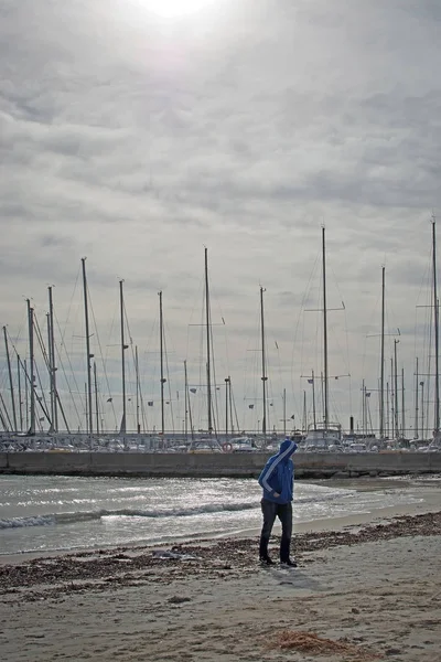 Молодой человек в капюшоне на пляже — стоковое фото